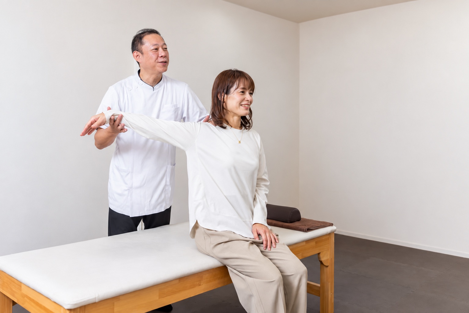 SHINBO院長が肩・腕の動きを確認している実際の施術風景